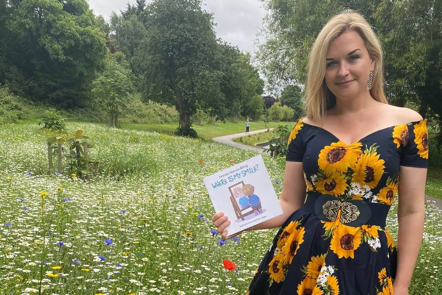 Natalie Reeves Billing poses with a copy of Where Is My Smile? — a book about children's mental health